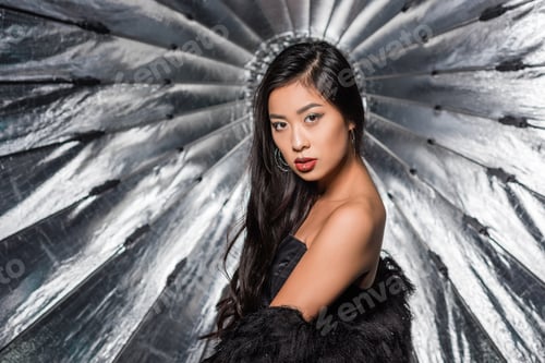 Preview: beautiful asian woman wearing ostrich feathers coat and looking at camera