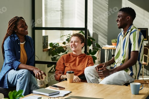 Preview: Happy young multicultural colleagues laughing at break