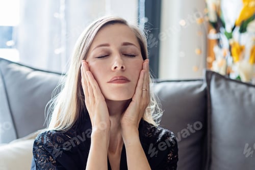 Preview: Young caucasian woman with blonde hair treat yourself at home in modern apartment on couch