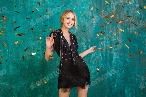 Preview: woman in party dress celebrating new year with golden confetti