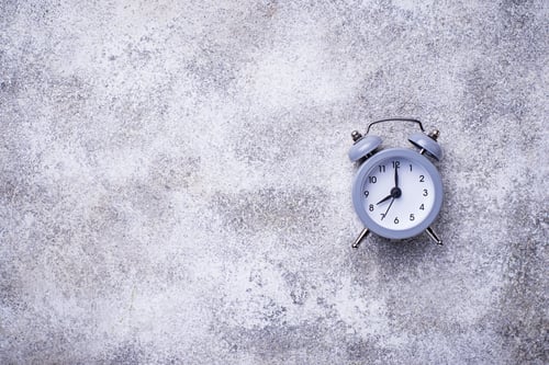 Preview: Grey vintage alarm clock on concrete table