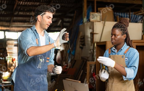 Preview: Carpenter and his assistant working together in a carpentry workshop