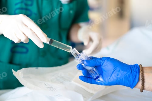 Preview: Surgeons injecting yellow liquid into a test tube during medical procedure