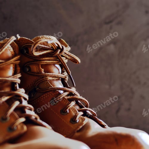Preview: Yellow leather used work boots on concrete background closeup. P