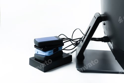 Preview: Multiple external hard drives connected to a monoblock on a white background.Computer with hard