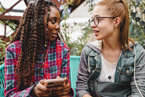 Preview: Two young multiethnic women bonding together and talking together