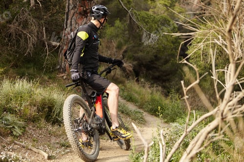 Preview: Spending Sunday morning outdoors. Unrecognizable young mountain biker in black cycling clothing keep