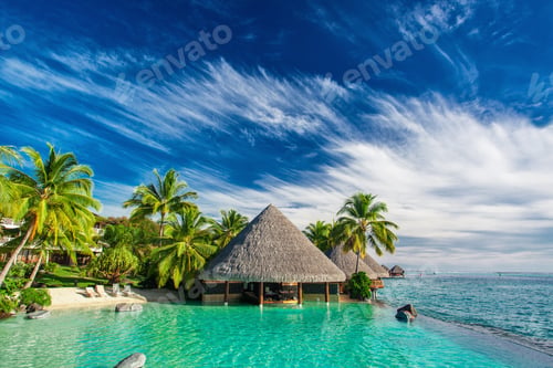 Preview: Infinity pool with artificial beach and bar next to tropical oce