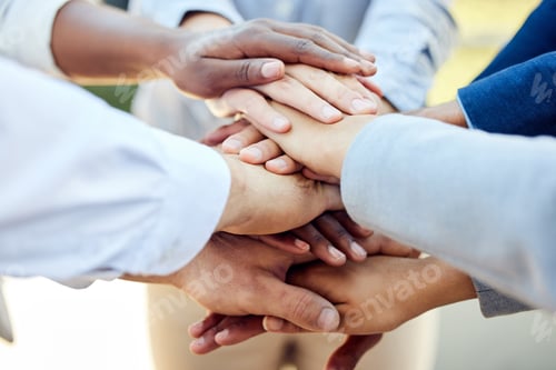 Preview: Shot of a group of unrecognizable businesspeople stacking their hands together outside
