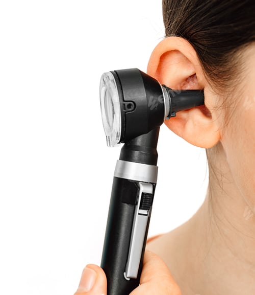 Preview: Hearing exam. Otoscope and ear of a child close-up isolated on white. Hearing test in a clinic.