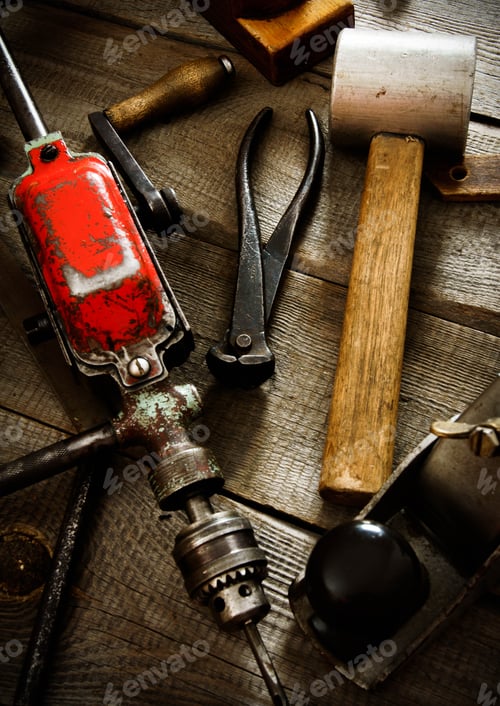 Preview: Many old working tools ( drill, mallet, saw and others) on a wooden background.