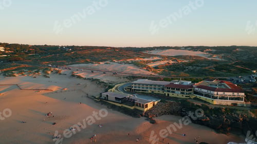 Preview: Drone view cozy resort on sandy seashore at evening sunlight. Cars riding road.