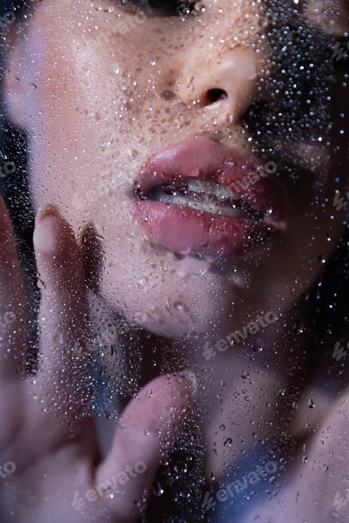 Preview: Cropped view of sexy woman touching wet glass on black background