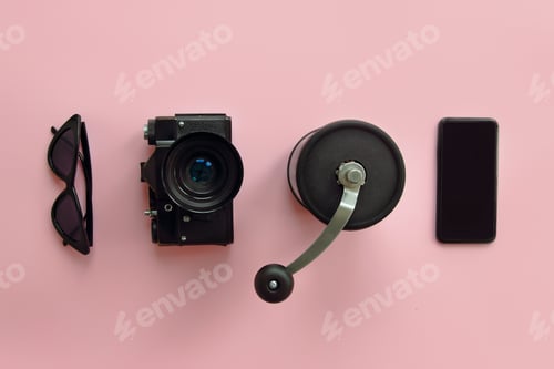 Preview: Black sunglasses,smartphone,photo camera and notebook on pink background