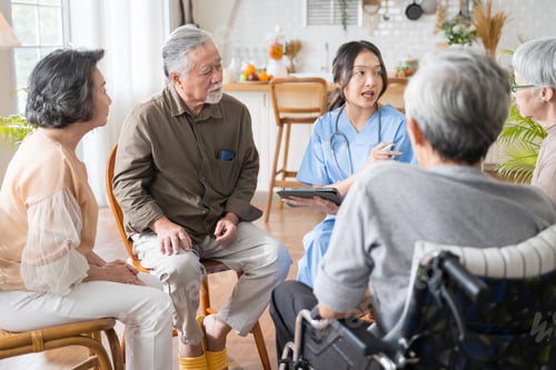 Preview: Senior people sit in a circle in a nursing home and listen to nurse during a group elderly therapy