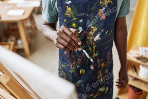 Preview: Focus on hand of young African American artist with paintbrush