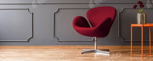 Preview: Flowers on an orange side table, a fancy, burgundy red armchair