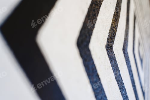 Preview: Lines like black arrows on white background painted on a wall indicating direction.