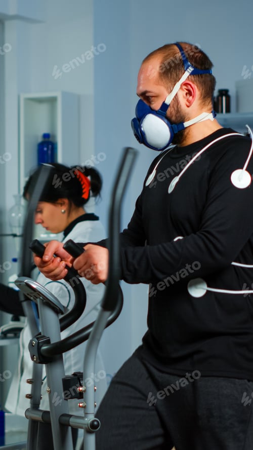 Preview: Sportsman running on cross trainer in lab facility for sports performance