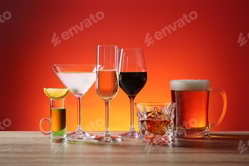 Preview: Different alcohol drinks on wooden table against red background
