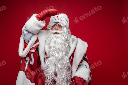 Preview: Senior Santa Claus looking away with hand at head.