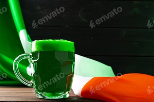 Preview: Glass of green beer against flag of Ireland