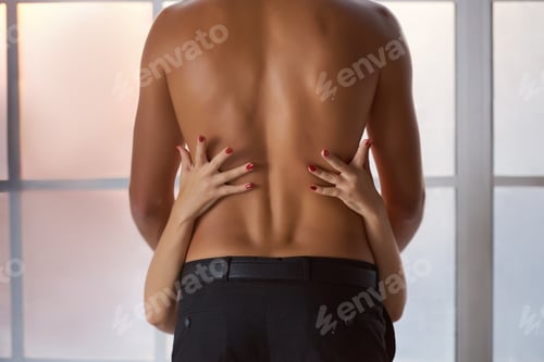 Preview: Womans arms embracing mans torso, backside view.