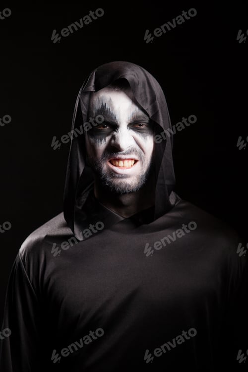 Preview: Grim reaper with a scary face isolated over black background