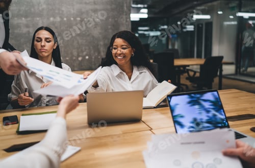 Preview: Diverse women sitting at table during meeting in office