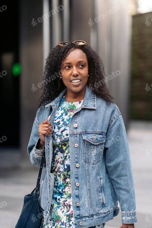 Preview: Stylish Woman in Denim Jacket Walks in City