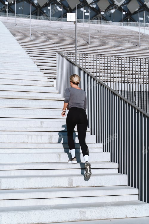 Vorschau: Sportlerin läuft und trainiert auf der Treppe zwischen den Tribünen des Außenstadions
