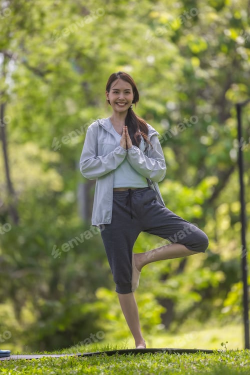Preview: Young Asian woman revitalized through park yoga, meditation, aligning body, mind, restoring energy.