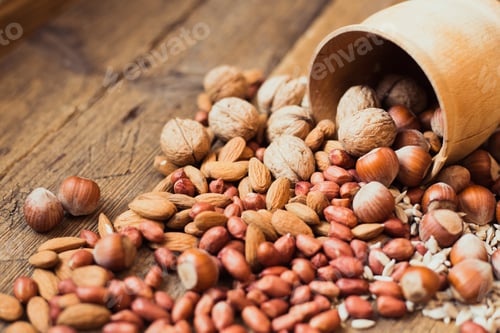 Preview: Wooden Bowl Spilling Mixed Nuts on Table