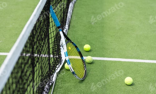 Preview: Tennis balls and racket on a green tennis hard court