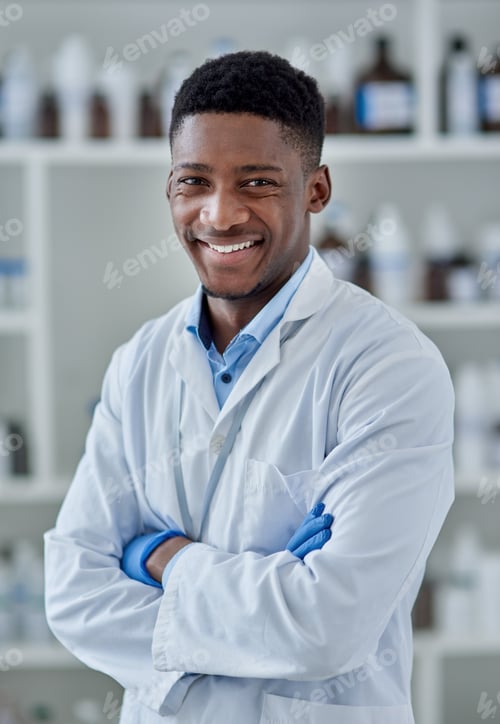 Preview: Portrait of a cheerful young male scientist standing with arms folded inside of a laboratory