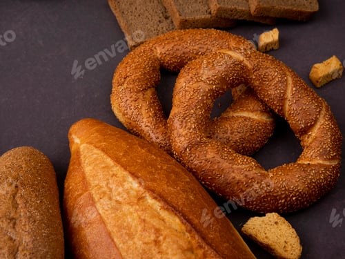 Preview: side view of breads as sandwich bread, baguette, bagel on maroon background with copy space