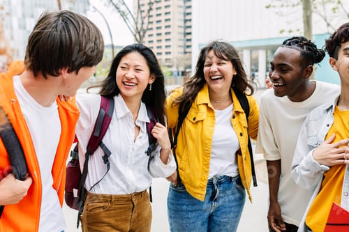 Preview: Multiracial group of happy students laughing and having fun together at college
