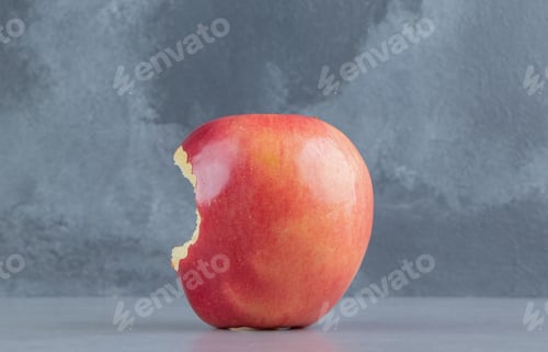 Preview: Bitten apple displayed on marble background