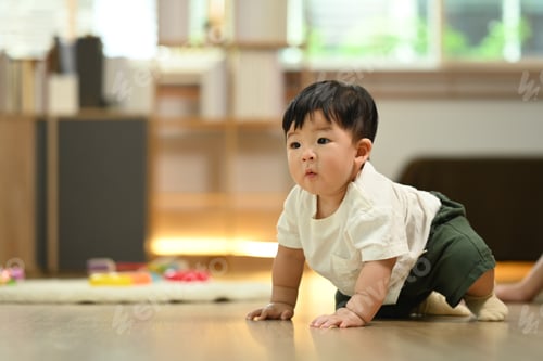 Preview: Cute little baby boy having fun crawling on floor. Child development concept