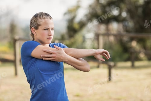 Preview: Fit woman performing stretching exercising during obstacle course