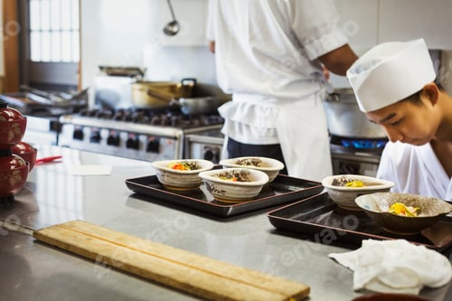 Preview: Two chefs working at a counter at a Japanese sushi restaurant.