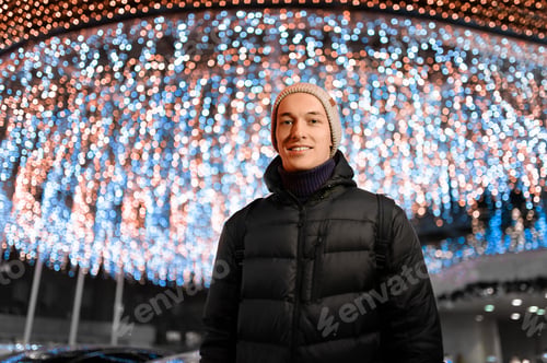 Preview: City Night Portrait Of A Handsome And Young Guy Warmly Dressed Against A Background Of Lights In