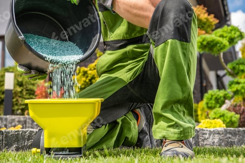 Preview: Gardener Filling His Handheld Spreader with Granular Lawn Fertilizer