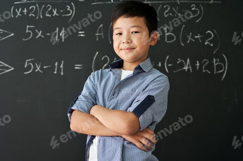 Preview: Portrait of happy proud asian boy standing on chalkboard background.