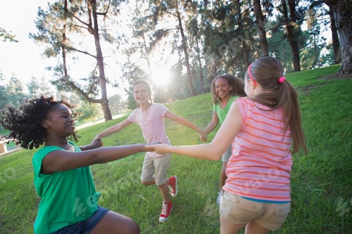 Preview: A group of four girls holding hands and dancing outside.