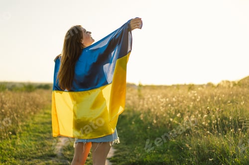 Preview: Ukrainian wonam in white t shirt with yellow and blue flag of Ukraine in field.