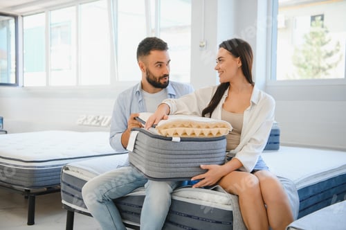 Preview: A young couple is choosing bedding at a bed, mattress and pillow store.