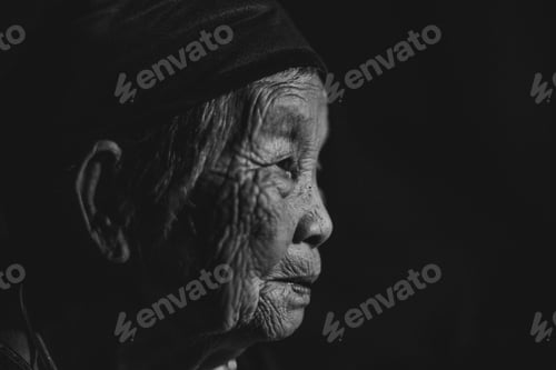 Preview: Elderly person lost in thought in a black and white portrait