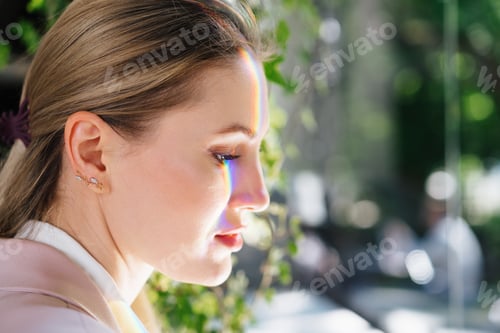 Preview: Portrait of an attractive woman with rainbow light across face