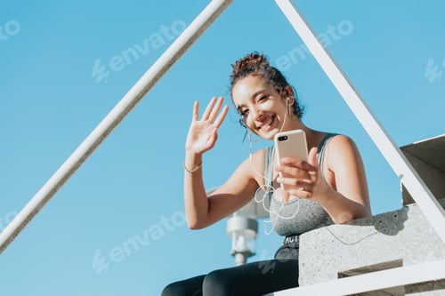 Preview: Young Woman Smiling While Video Chatting Outdoors
